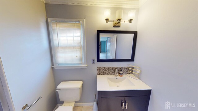 bathroom with toilet, tasteful backsplash, tile patterned floors, ornamental molding, and vanity