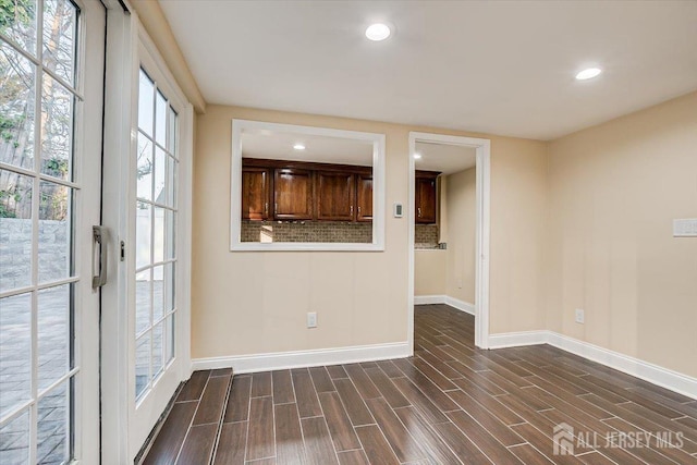 spare room featuring recessed lighting, baseboards, and wood tiled floor