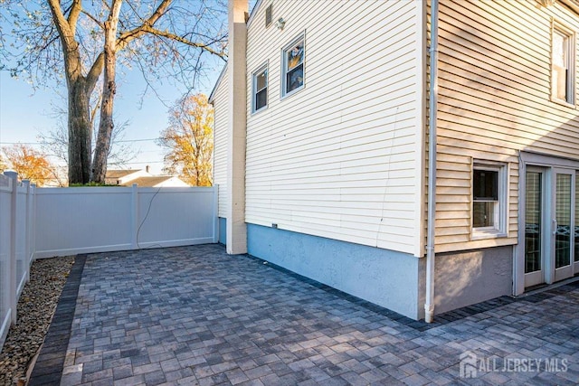 view of side of property with a patio and fence