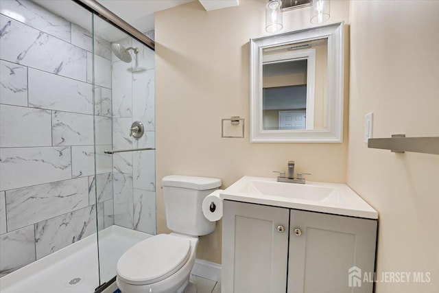 bathroom featuring vanity, toilet, and a stall shower