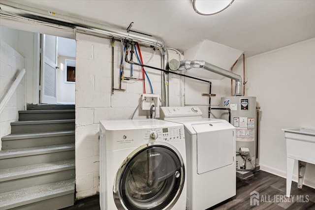 clothes washing area with dark wood-style floors, water heater, separate washer and dryer, concrete block wall, and laundry area