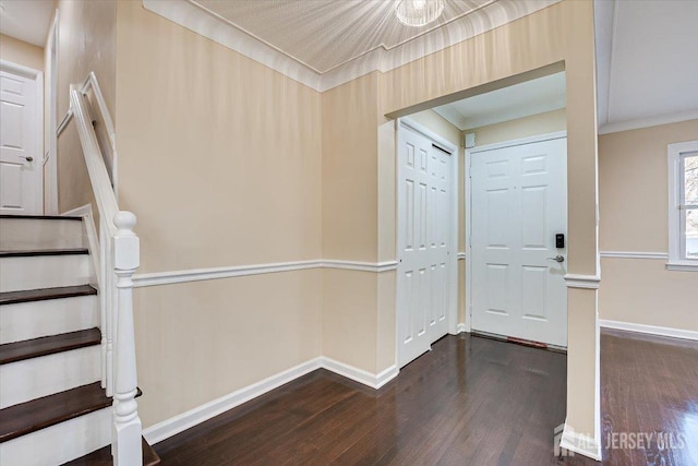 entryway with dark wood finished floors, stairway, baseboards, and ornamental molding