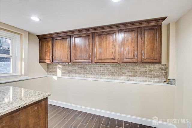 kitchen featuring light stone counters, decorative backsplash, recessed lighting, and dark wood-style flooring