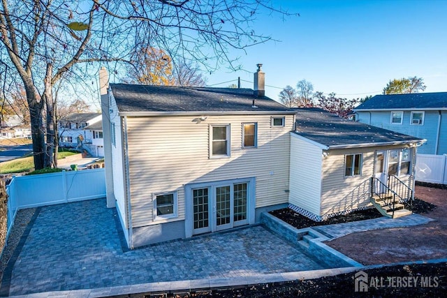 rear view of house with a patio area, fence, and a chimney