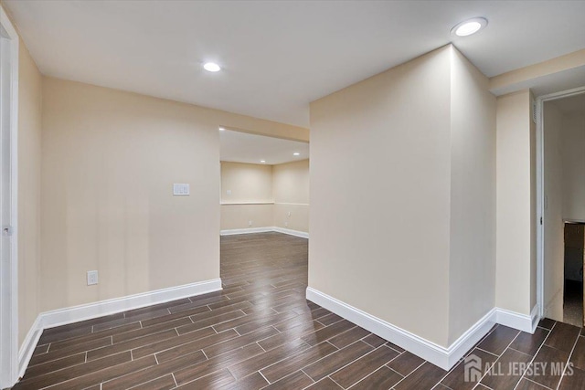 spare room with wood finish floors, baseboards, and recessed lighting