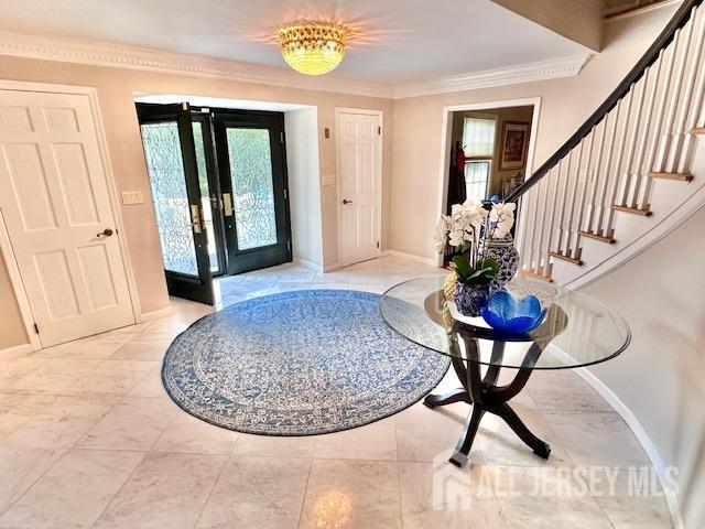 foyer with french doors and ornamental molding