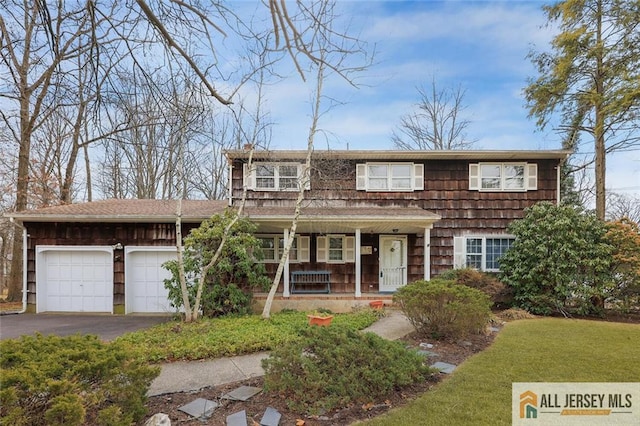 view of front of house featuring covered porch, driveway, and a garage