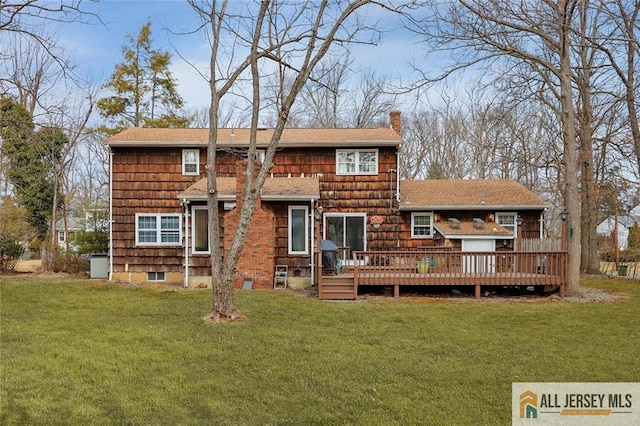 back of property featuring a deck, a chimney, a yard, and roof with shingles