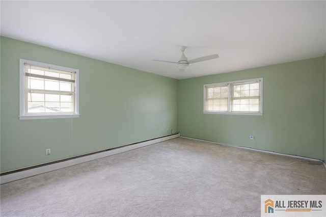 spare room with a baseboard heating unit, plenty of natural light, carpet flooring, and ceiling fan