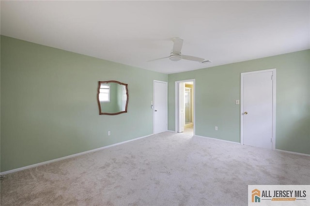 carpeted spare room with baseboards and a ceiling fan