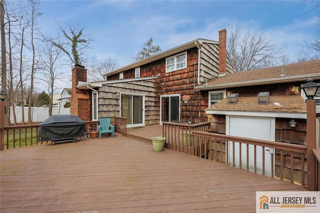 wooden deck featuring a grill and fence