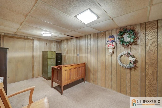 home office featuring wooden walls, carpet flooring, and a drop ceiling