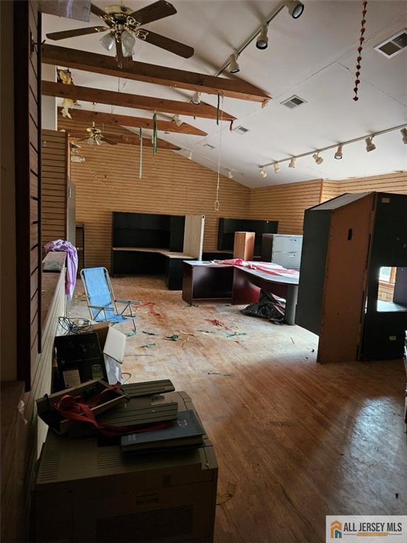 interior space featuring hardwood / wood-style floors, vaulted ceiling with beams, and ceiling fan