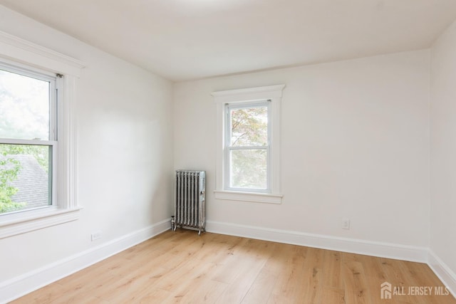 345 1st St, Dunellen, NJ 08812 - unfurnished room featuring radiator, light wood-style floors, and baseboards
