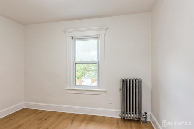 345 1st St, Dunellen, NJ 08812 - spare room featuring radiator, light wood-style flooring, and baseboards