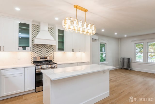 345 1st St, Dunellen, NJ 08812 - kitchen featuring radiator heating unit, stainless steel range with gas cooktop, custom range hood, a wall mounted AC, and light wood-style flooring