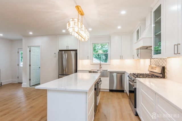 345 1st St, Dunellen, NJ 08812 - kitchen with appliances with stainless steel finishes, a sink, a center island, light wood-style floors, and white cabinets