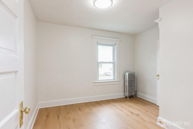 345 1st St, Dunellen, NJ 08812 - empty room with radiator, light wood-type flooring, and baseboards