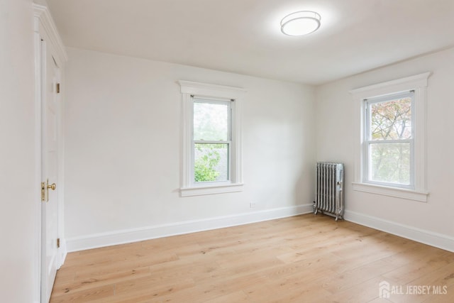 345 1st St, Dunellen, NJ 08812 - unfurnished room featuring radiator heating unit, light wood-style floors, healthy amount of natural light, and baseboards