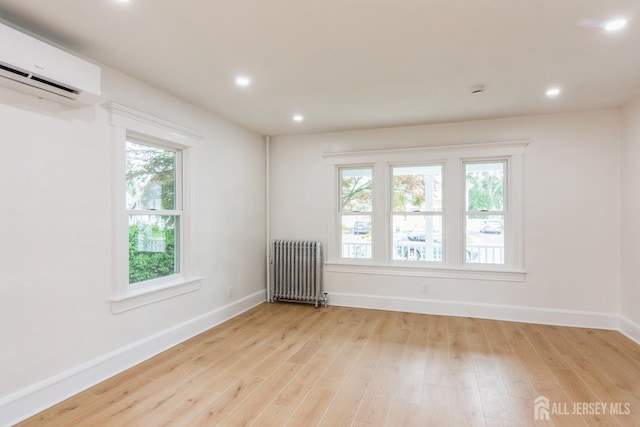 345 1st St, Dunellen, NJ 08812 - empty room featuring radiator heating unit, a wall unit AC, light wood-style floors, baseboards, and recessed lighting