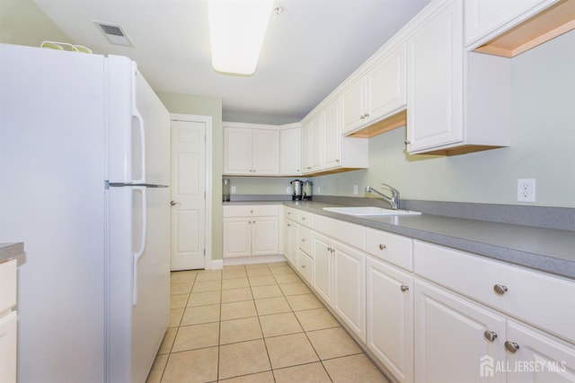 101 Liddle Ave, Edison, NJ 08837 - kitchen featuring freestanding refrigerator, a sink, light tile patterned floors, and white cabinets