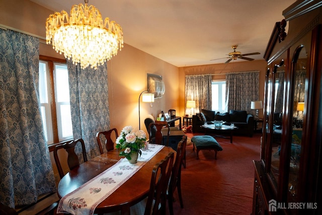 carpeted dining area with ceiling fan with notable chandelier