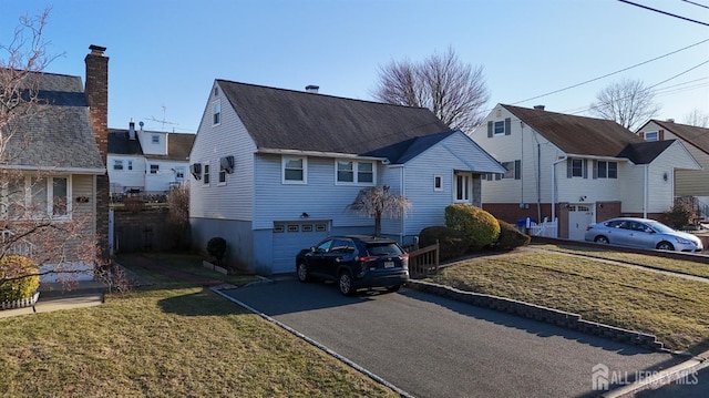 view of front of property featuring driveway, a front yard, a garage, and roof with shingles