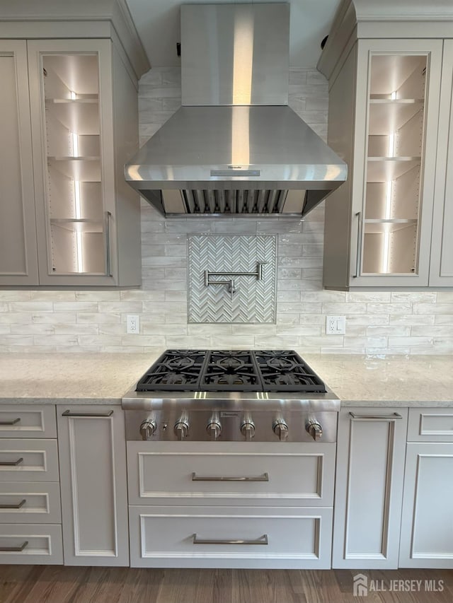 2 Joye Ln, South Brunswick, NJ 08852 - kitchen with island range hood, stainless steel gas stovetop, light stone counters, and glass insert cabinets