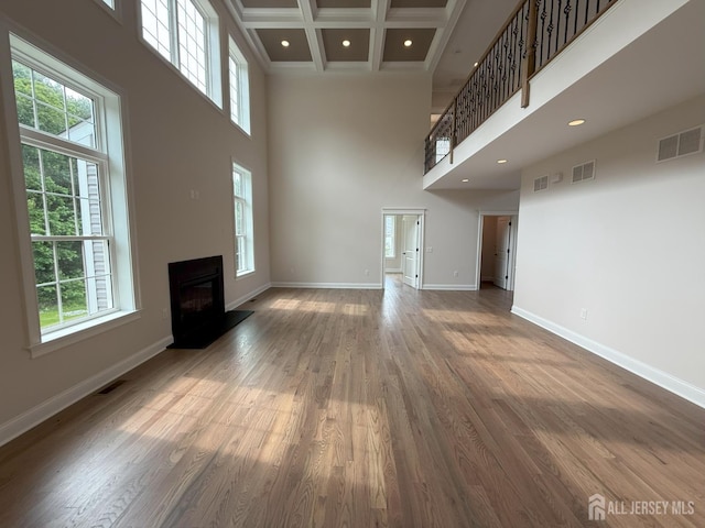2 Joye Ln, South Brunswick, NJ 08852 - unfurnished living room with a high ceiling, healthy amount of natural light, a fireplace with raised hearth, beamed ceiling, and wood finished floors