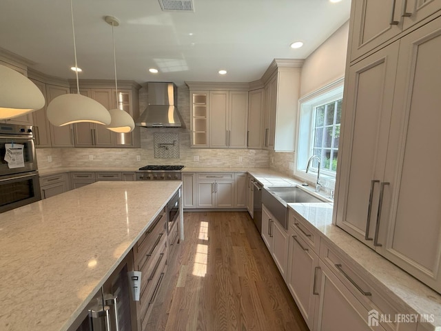 2 Joye Ln, South Brunswick, NJ 08852 - kitchen with wall chimney exhaust hood, stainless steel appliances, wood finished floors, light stone counters, and backsplash