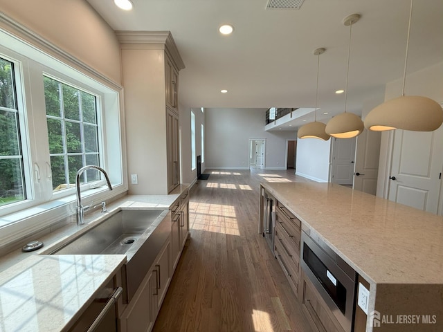 2 Joye Ln, South Brunswick, NJ 08852 - kitchen featuring stainless steel microwave, dark wood-style floors, open floor plan, light stone counters, and hanging light fixtures