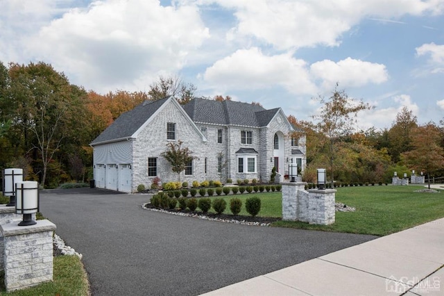 2 Joye Ln, South Brunswick, NJ 08852 - view of front of home with stone siding, a front yard, asphalt driveway, and a garage