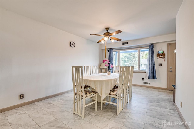 dining room featuring visible vents, a ceiling fan, baseboards, and marble finish floor
