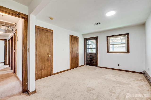 unfurnished bedroom with baseboards, visible vents, multiple closets, and light colored carpet