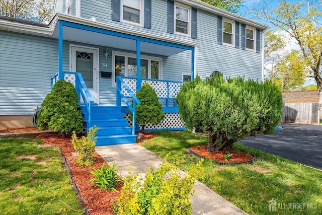 view of front of house with covered porch and fence