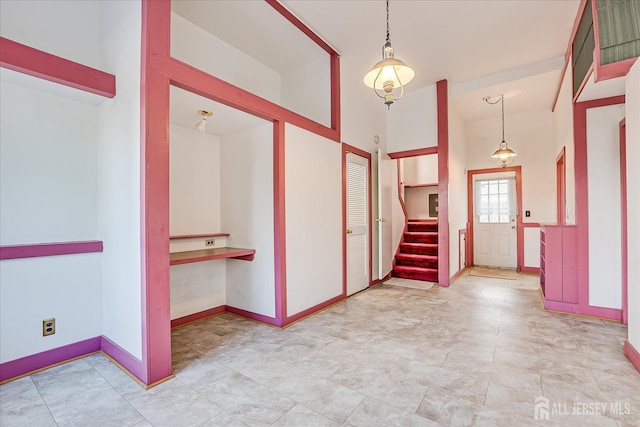foyer with stairs and baseboards