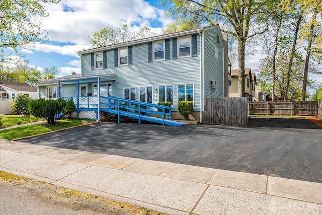 view of front of property featuring fence and a porch