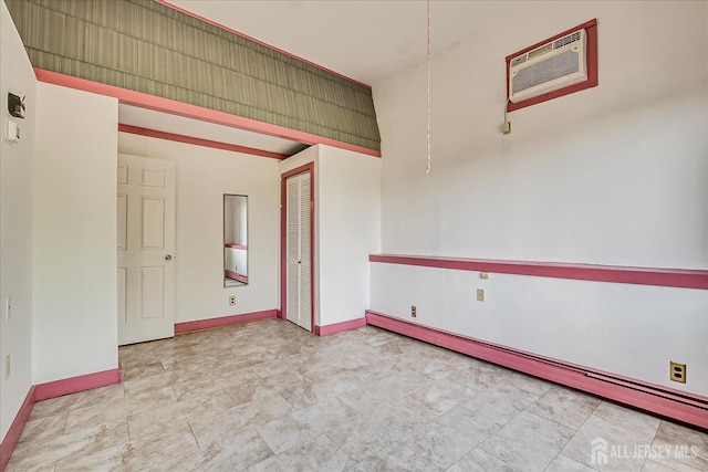 empty room featuring baseboards, baseboard heating, and a wall mounted AC