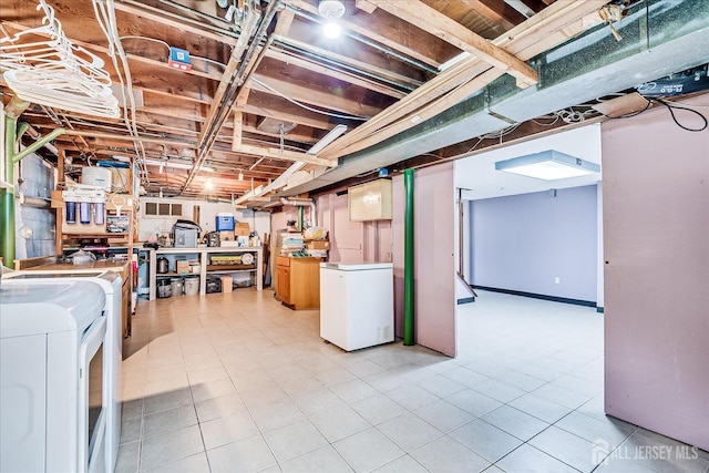 unfinished below grade area featuring washer and dryer and refrigerator