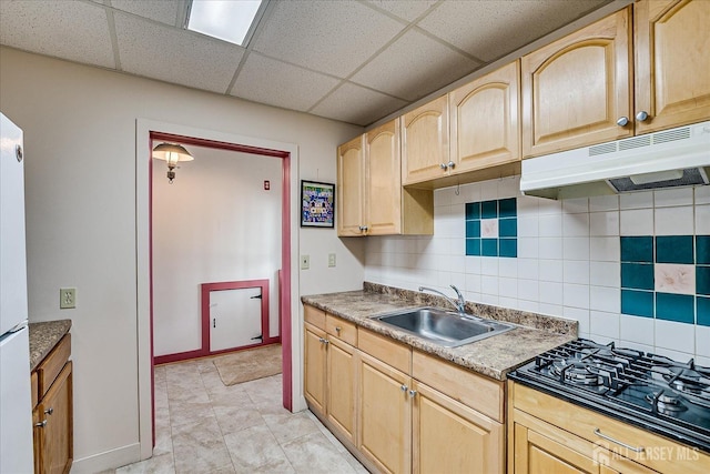 kitchen with decorative backsplash, black stovetop, a sink, light brown cabinets, and under cabinet range hood