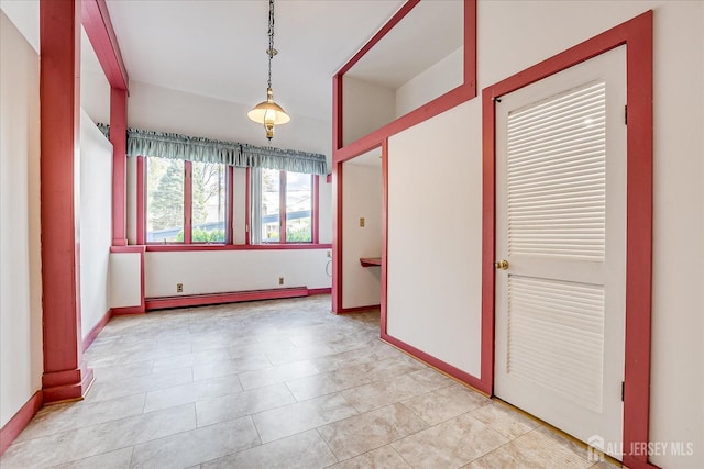 empty room featuring baseboards, light tile patterned flooring, and baseboard heating