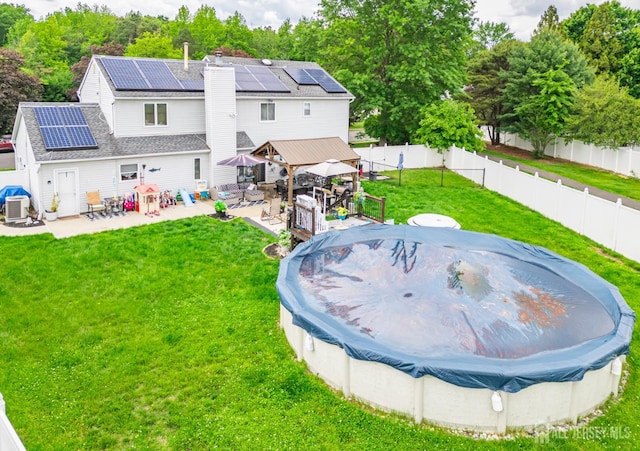 24 Higgins Rd, Old Bridge, NJ 08857 - back of house with a gazebo, roof mounted solar panels, a chimney, a patio, and central AC unit
