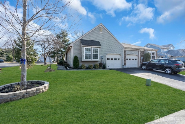 view of front of property featuring a front lawn, a garage, and driveway