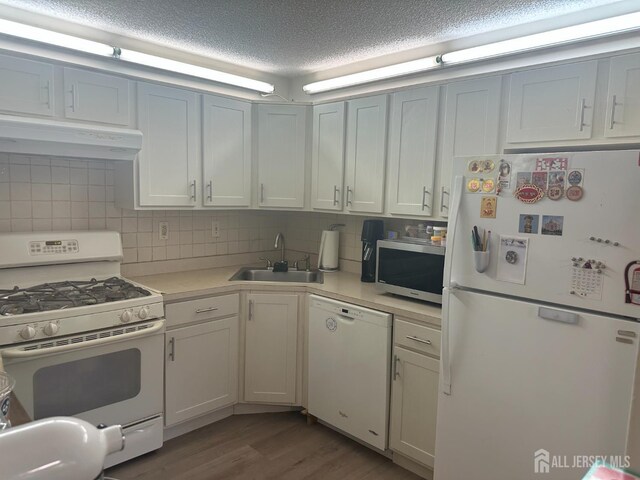167 Rachel Ct, Franklin Twsp, NJ 08823 - kitchen with white appliances, under cabinet range hood, a sink, light countertops, and wood finished floors