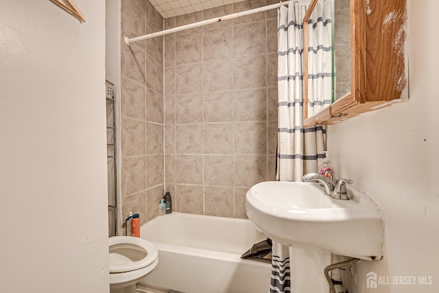 full bathroom featuring sink, shower / bath combination with curtain, and toilet