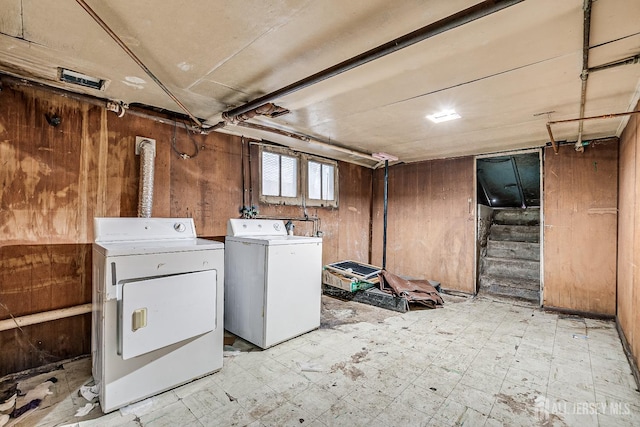 laundry room with washer and clothes dryer and wood walls