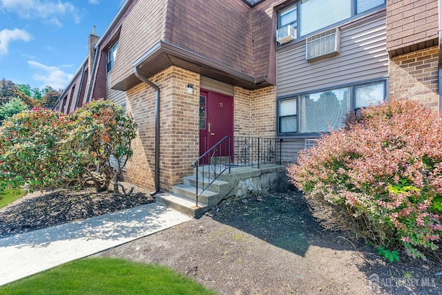 1133 Livingston Ave Unit 11C, North Brunswick, NJ 08902 - view of exterior entry with brick siding, mansard roof, roof with shingles, and cooling unit