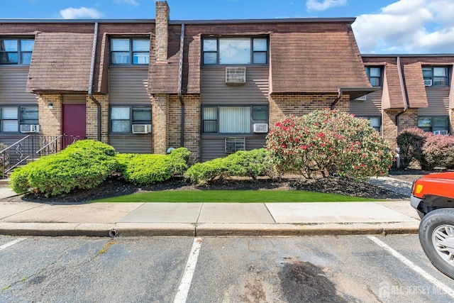 1133 Livingston Ave Unit 11C, North Brunswick, NJ 08902 - view of front of home with uncovered parking, brick siding, and cooling unit