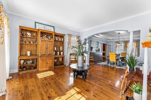 living room with arched walkways, ornamental molding, baseboards, and hardwood / wood-style floors