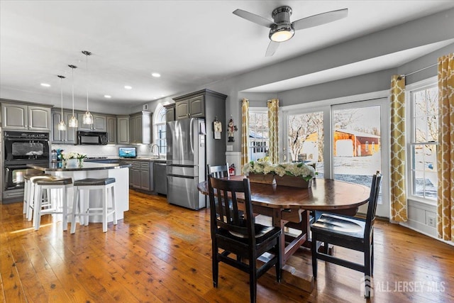 dining area with recessed lighting, a healthy amount of sunlight, and dark wood-type flooring